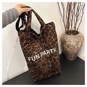 Close-up of leopard print canvas tote bag with FUN PARTY lettering and sturdy handles