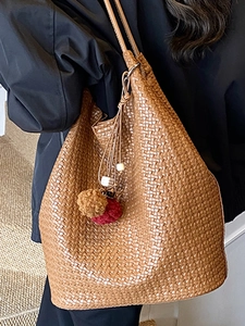 Retro brown woven bucket bag with elegant plush pom-pom charms and large capacity design