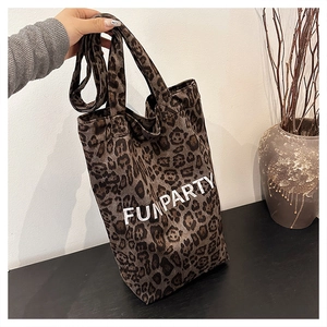 Detail of leopard print canvas tote bag featuring FUNPARTY text and thick handles
