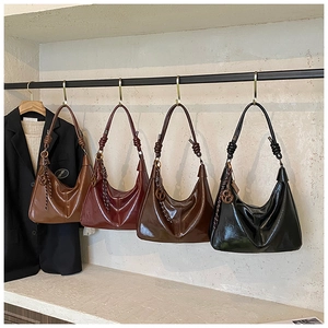 Détail de sacs en cuir ciré avec poignée à nœud et décoration en corde tressée