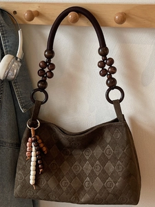 Brown suede tote bag with diamond pattern, beaded strap and GF logo on wooden hanger