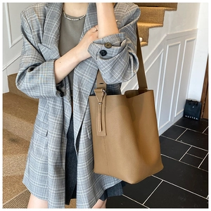 Detail of camel grainy leather bucket bag with wide strap for work and daily use
