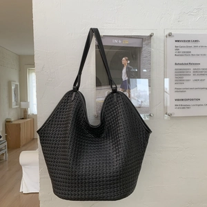 Detail of woven black leather bucket bag showing large capacity and premium texture