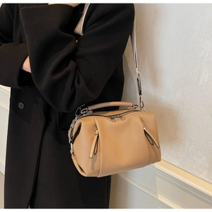 Detail of khaki Boston bag with pebble leather texture and adjustable shoulder strap
