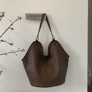 Detailed view of the dark brown woven texture and high-quality leather on this bucket bag