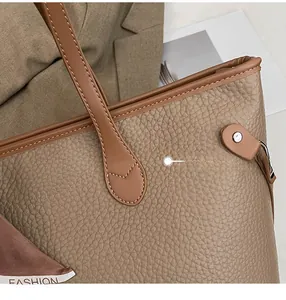 Detail view of khaki pebbled leather tote bag featuring a decorative brown fashion scarf