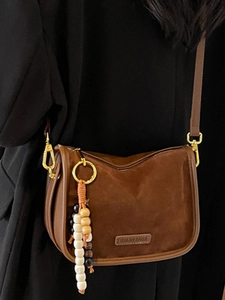 Deep brown suede crossbody bag with vintage bead pendant and gold hardware for women