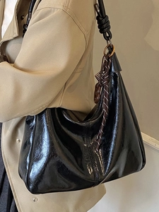 Sac hobo en cuir noir brillant avec bandoulière à nœud et détails en bronze