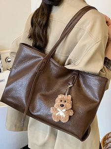 Chic dark brown tote bag with retro wrinkled leather and cute bear charm for daily commute