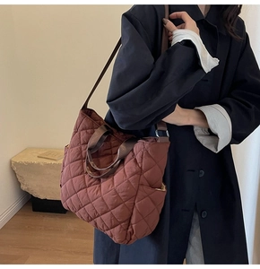 Dettaglio della borsa tote trapuntata rosso mattone in nylon con cuciture a rombi