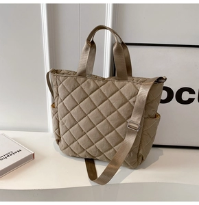 Dettaglio della borsa tote trapuntata kaki con tasca laterale e tracolla regolabile