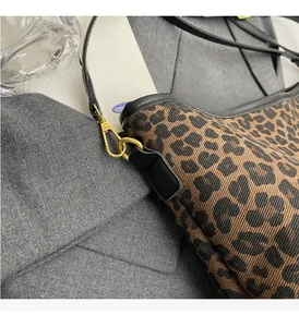 Detail of leopard print bucket bag featuring premium leather piping and gold metal hardware