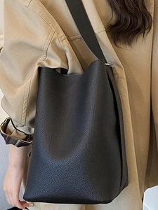 Minimalist black lychee pattern leather bucket bag with wide shoulder strap for women