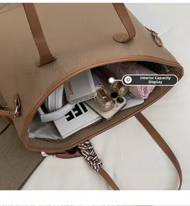 Close-up of brown litchi leather tote bag showing large interior capacity for daily items