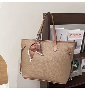 Detailed view of brown leather tote bag featuring a decorative fashion silk scarf