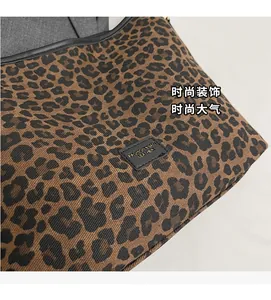 Detail of leopard print fabric texture and black leather brand tag on the bucket bag