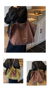 Detail of a reversible brown suede tote bag with leopard lining and a leather logo tag