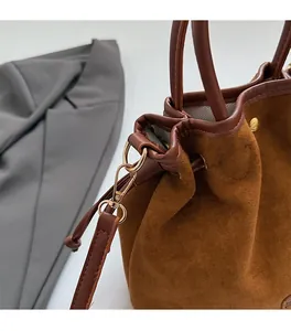 Detailed macro view of dark brown matte bucket bag featuring premium gold metal hardware