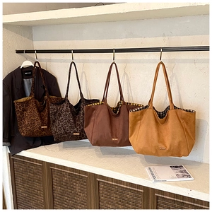Detailed close-up showing leopard print canvas tote bags with plaid lining and leather label