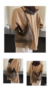 Close-up of leopard print bucket bag with black leather straps and gold metal hardware