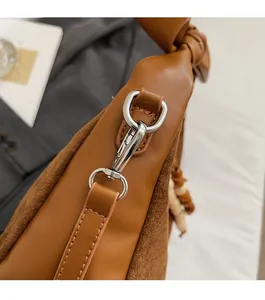 Détail du sac bandoulière marron en cuir avec boucle argentée et bride nouée