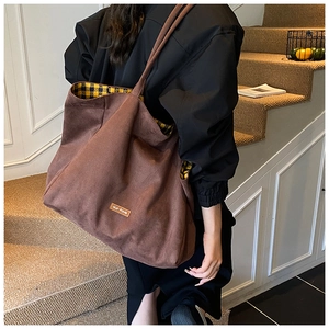 Close-up of brown corduroy tote bag featuring plaid lining and our fave leather label