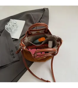 Spacious interior of a brown bucket bag showing open storage and inner pocket for essentials