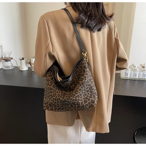 Detailed view of the leopard print hobo bag with gold hardware and black leather strap