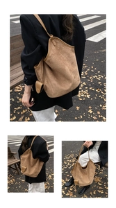 Detail of a large vintage brown suede tote bag with a matching small pouch on city street