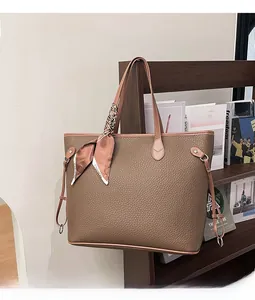 Detail of large brown lychee leather tote bag featuring a decorative fashion silk scarf
