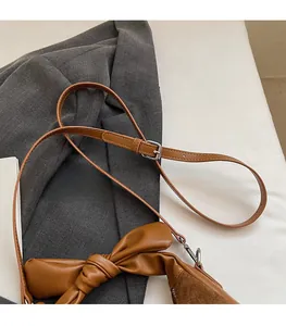 Détails de la bandoulière réglable et du design noué du sac à main marron en cuir