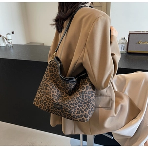 Detail of vintage leopard print hobo bag with black leather strap on a shoulder