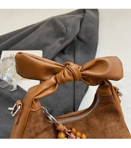Vue détaillée du sac porté épaule en daim marron avec anse en nœud et perles vintage