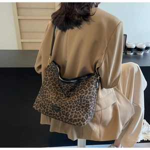 Detailed close-up of leopard print pattern and black leather brand tag on bucket bag