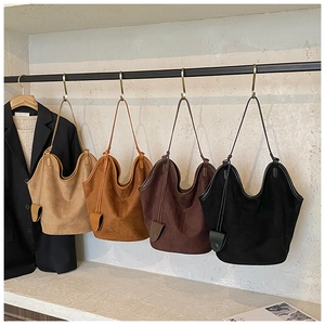 Detailed close-up showing four vintage suede bucket bags in different neutral colors