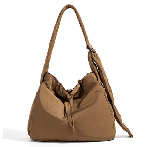 Detail view of large brown drawstring tote with padded nylon texture and side pocket