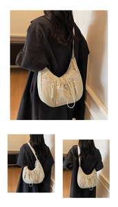 Macro detail of beige pleated nylon crescent bag with drawstring and woven zipper puller