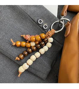 Gros plan d'un bijou de sac en perles de bois multicolores avec anneau sur un sac à main