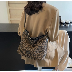 Detailed close-up of leopard print bucket bag with black leather trim and metal logo