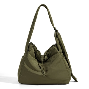 Detail of olive green drawstring bag with adjustable strap and side pockets macro