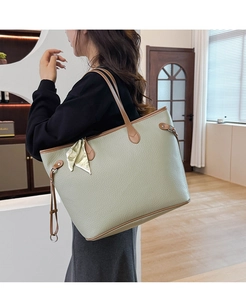 Sage green textured leather tote bag detail with brown trim and elegant silk scarf handle