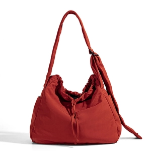 Large brick red nylon tote bag with drawstring closure and adjustable wide shoulder strap