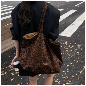 Detail shot of the large leopard print canvas tote bag with a small leather brand label