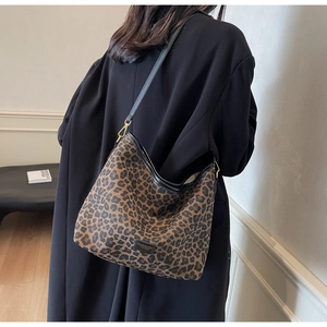 Close-up of stylish leopard print hobo bag with black leather strap and gold hardware