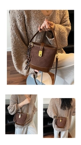 Λεπτομέρεια καφέ καπιτονέ τσάντα bucket με χρυσό κούμπωμα και δερμάτινη υφή σουέτ
