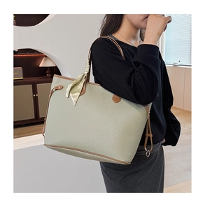 Macro shot of green lychee leather tote bag featuring brown straps and silk scarf detail