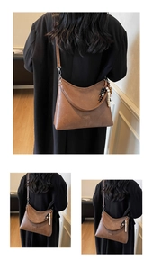 Detail of a brown leather crossbody bag with beaded tassel and adjustable silver buckle