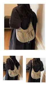 Detail of half-moon nylon crossbody bag with drawstring design and zippered pockets