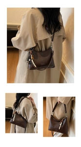 Detail showing vintage brown faux leather hobo bag with unique beaded charm and metal logo