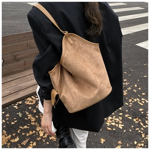 Detail of light brown suede tote bag with a small matching pouch in an autumn setting